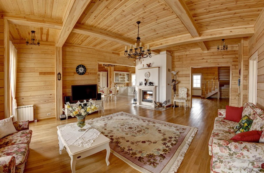 Гостиная в деревянном доме: камин и другие атрибуты в интерьере комнаты,  фото