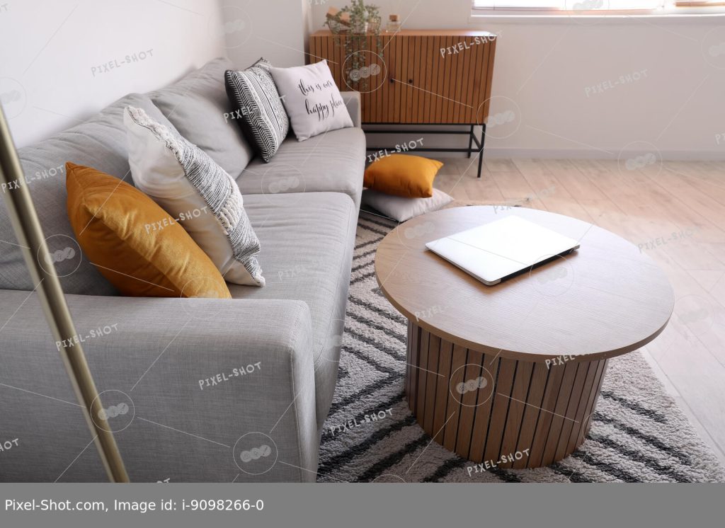 Современный ноутбук на журнальном столике возле серого дивана в стильной  гостиной :: Стоковая фотография :: Pixel-Shot Studio
