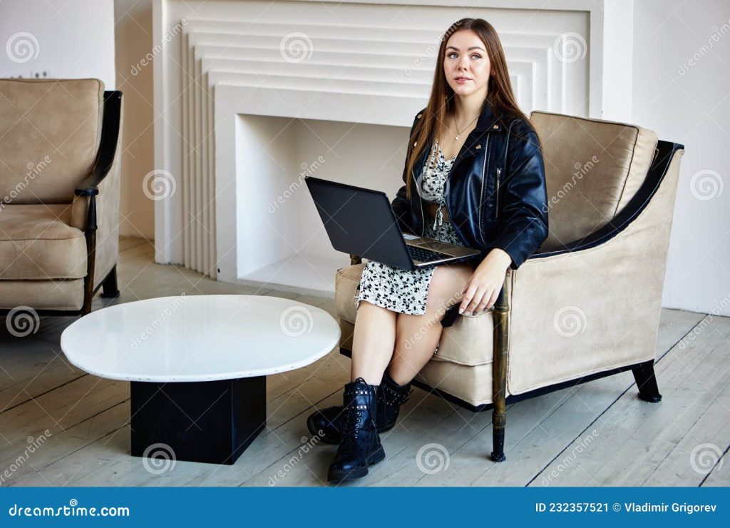женщина в кожаных кожаных военных ботинках сидит в помещении с ноутбуком.  Стоковое Изображение - изображение насчитывающей бой, работа: 232357521